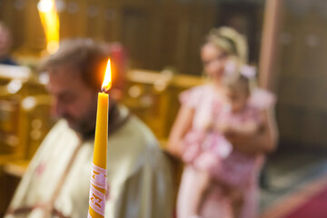 Wall Mural - Burning candle at Orthodox christening with blurred background