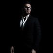 © Mark - Business portrait of a young caucasian man in a black classic suit on a black background.