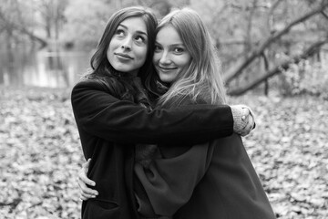 Two girls hugging in the autumn park