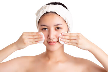 Asian woman clean beautiful face by wiping, using cotton pads, cleansing lotion, facial toner. Attractive beautiful young lady has beauty facial skin, bright facial skin. Facial skin care concept.