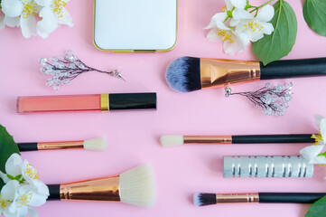 Wall Mural - premium makeup brushes, eyeshadow palette and blush on a colored pink background, creative cosmetics flat lay