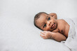© Ursula Page - Happy, awake and cute African-American newborn baby boy laying on a cream-colored blanket