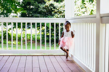 Young Ballerina Playing On Front Porch At Home