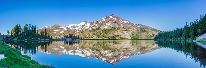 Wall Mural - mountain landscape with clear blue sky, morning light, reflective water, and a wide panoramic view.
