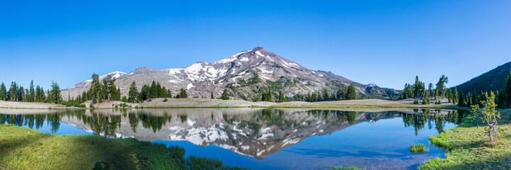 Wall Mural - mountain landscape with clear blue sky, morning light, reflective water, and a wide panoramic view.