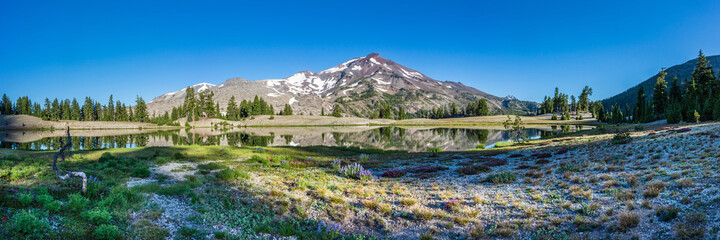 Wall Mural - mountain landscape with clear blue sky, morning light, reflective water, and a wide panoramic view.