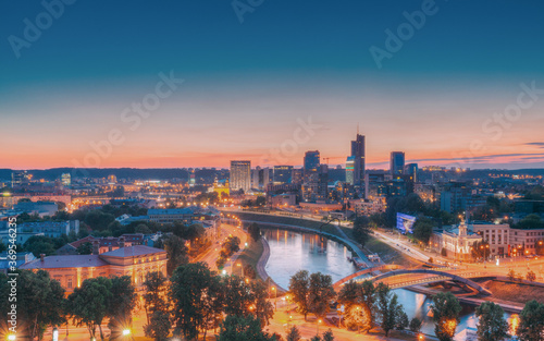 Fototapeta na szkło Vilnius, Lithuania, Europe. Sunset Cityscape. Modern Office Buildings Skyscrapers In Business District New City Center Shnipishkes In Night Illuminations