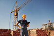 © standret - Holds notepad with documents. Construction worker in uniform and safety equipment have job on building