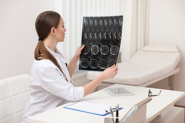 Sticker - Orthopedist examining X-ray picture at desk in clinic