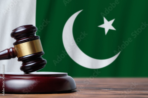 Justice and court concept in Islamic Republic of Pakistan. Judge hammer on a flag background