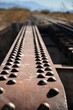 Vertical closeup of and old railway steel bridge in the foreground and mountains in the background
