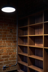 Wall Mural - Empty wooden shelves along the brick wall with a hanging lamp