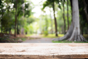 Empty wooden desk space and blurry background of garden or park for product display montage.