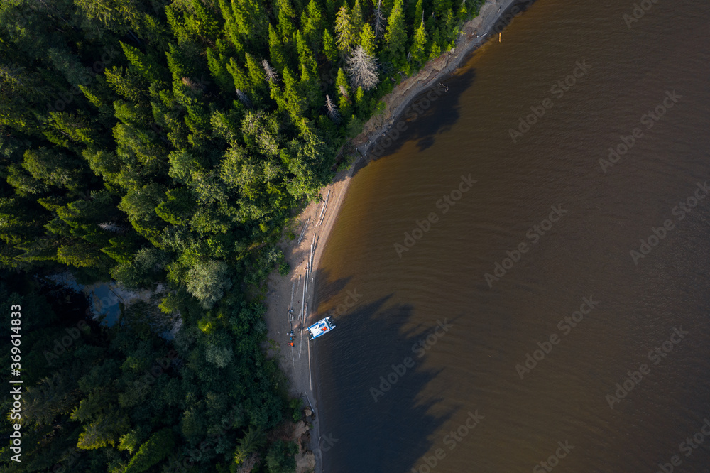 Aerial view of the wild narrow beach with anchored white vessel - obrazy, fototapety, plakaty 