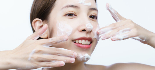 Asian woman wash her face with bubble cleansing foam isolated on white background.