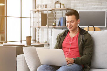 Poster - Man with earphones and laptop working in office