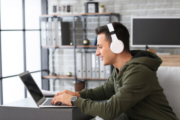 Poster - Man with headphones and laptop working in office