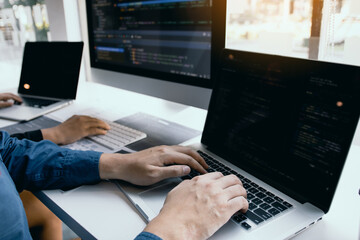 two software developers are analyzing together about the code written into the program on the comput