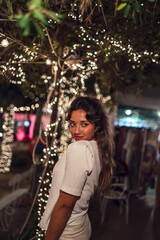 Sticker - Vertical shot of a young caucasian female with Christmas lights background