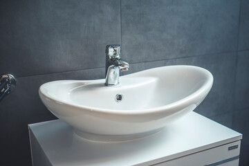 Faucet and water drop close up. Bathroom interior with sink and water tap.