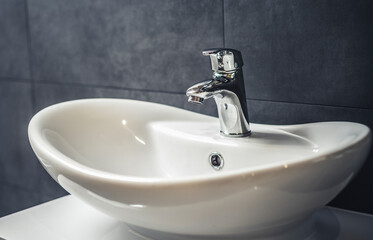 Wall Mural - Faucet and water drop close up. Bathroom interior with sink and water tap.