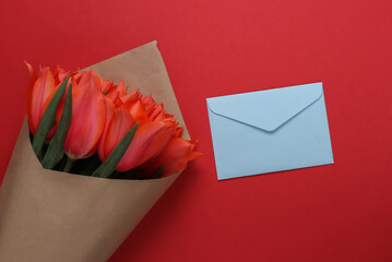 Sticker - Envelope and bouquet of red tulips on red background. Birthday, Valentine's Day or marriage proposal. Top view