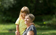 © ulza - Child girl embracing Grandmother  spending time together in nature. Concept of friendly family. Quality Time. copy space