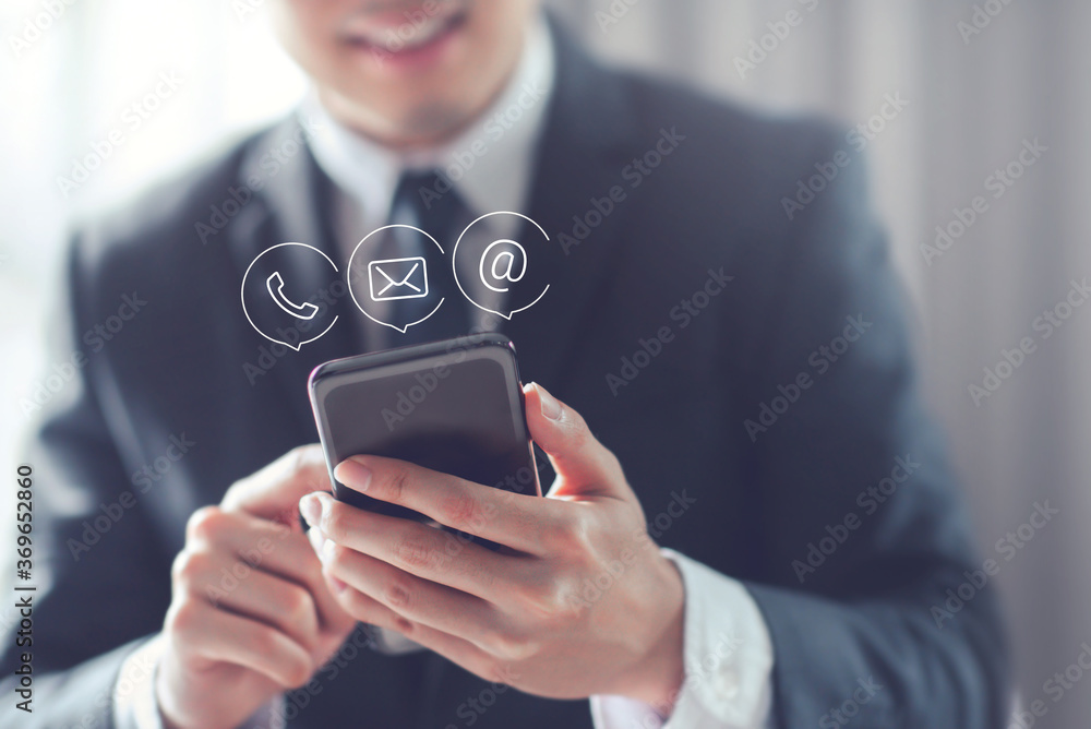 CONTACT US, Happy Businessman holding mobile smartphone with ( mail,phone,email ) icon. cutomer support concept, copy space. - obrazy, fototapety, plakaty 