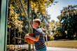 Young boy holding a basketball and looking through fence