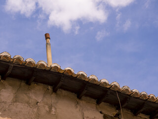 Canvas Print - Low angle shot of the roof of a rural house on a cloudy day