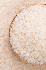 Wall Mural - Raw rice in a bowl and full frame in the white background table, top view overhead shot, close up