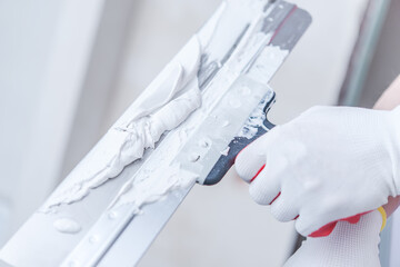 Close Up Of Professional Worker Patching Drywall.