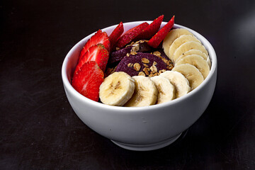 Wall Mural - Closeup shot of a white bowl with strawberry and banana slices