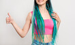 © golubovy - Millennial gen woman with blue hair braids. Like gesture. Cheerful lady in pink crop top with dyed dreads showing thumb up isolated on white. Creative hairstyle. Perfect choice.