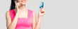 © golubovy - Banking service. Call center. Happy woman in pink verifying credit card on phone isolated on light empty space. Modern technology. Online shopping. Money transaction.