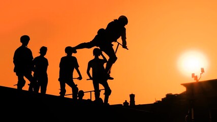 Wall Mural - Unrecognizable teenage boy silhouette showing high jump tricks on scooter against orange sunset sky at skatepark - slow motion. Sport, extreme, freestyle, outdoor activity concept