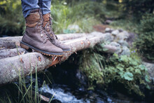 Closeup Of Woman Hiking Boots On Wooden Bridge In The Woods