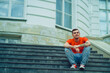 © Anton Dios - Male tourist sitting on steps of Palace. Young man poses on stairs of manor.