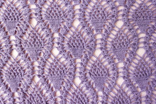Knitted Pattern From Lilac Yarn. Background For Handicraft And Hobby Goods. Top View.