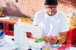 © karrastock - Man with cap sewing face masks at her home