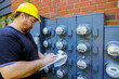 An electrician worker yellow hard hat inspection on writing reading of meter on clipboard