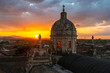 Dome of the La Merced church in Granada at sunset with Virgin Mary sculptures and the city skyline, Nicaragua.