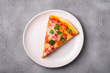 Hot Pizza Slice With Mozzarella Cheese, Ham, Tomato And Parsley On Plate, Stone Concrete Background, Top View