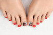 © Darya Lavinskaya - Manicure, pedicure beauty salon concept. Womans feet on gray background.