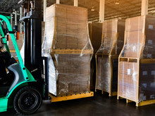 Worker Driving Forklift Loading And Unloading Shipment Carton Boxes And Goods On Wooden Pallet From Container Truck To Warehouse Cargo Storage In Logistics And Transportation Industrial 