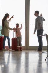 Wall Mural - Family with child looks out the window in the airport