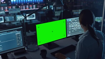 Wall Mural - Female Software Engineer Working in a Modern Monitoring Office with Green Screen Mock Up on a Computer Display. Monitoring Room Big Data Scientists and Managers Sit in Front of Computers.