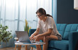 © StockPhotoPro - Woman sitting on the sofa and connecting with her laptop