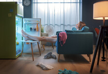 Woman Cooling Herself In Front Of The Open Fridge