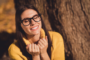 Wall Mural - Close up photo of positive cheerful girl have fall forest tree park rest relax touch collar enjoy sunny sun weather wear yellow sweater